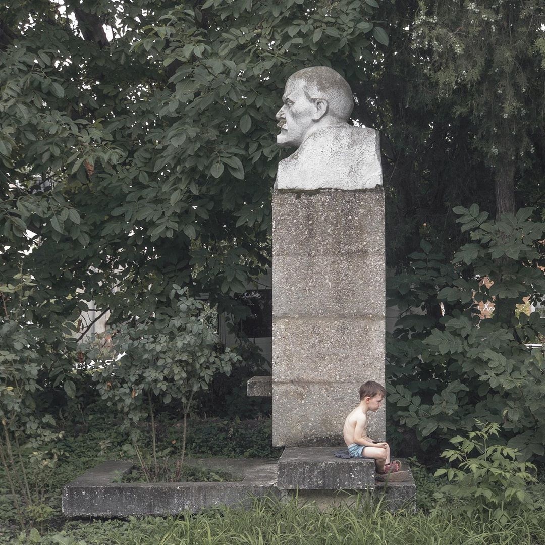 фотография Дмитрия Маркова: мальчик сидит у бюста Ленина