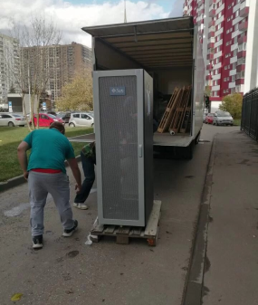 грузчик аккуратно складывает вещи в грузовик