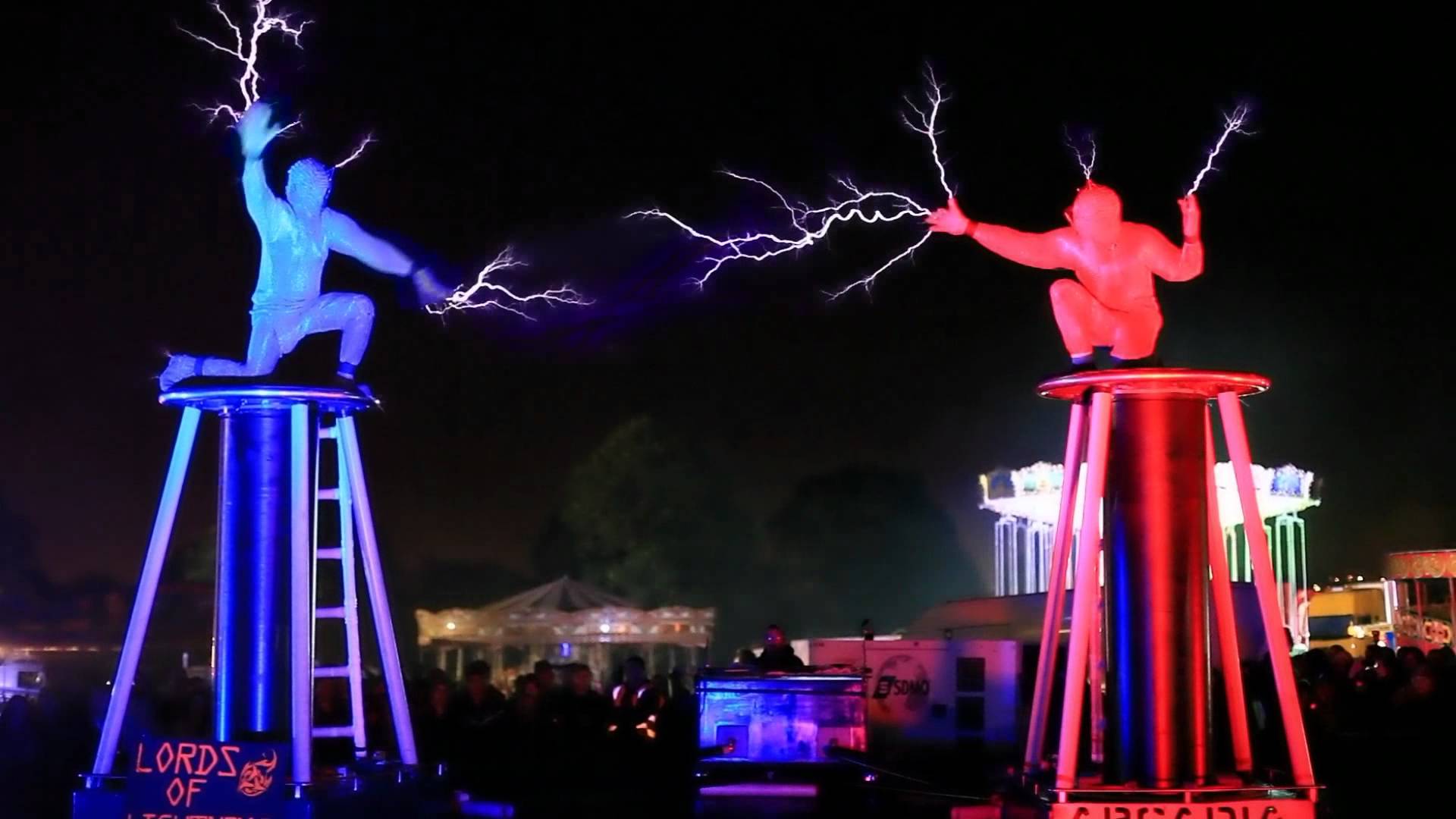 Два человека находящиеся на больших катушках Тесла метают друг в друга молнии 