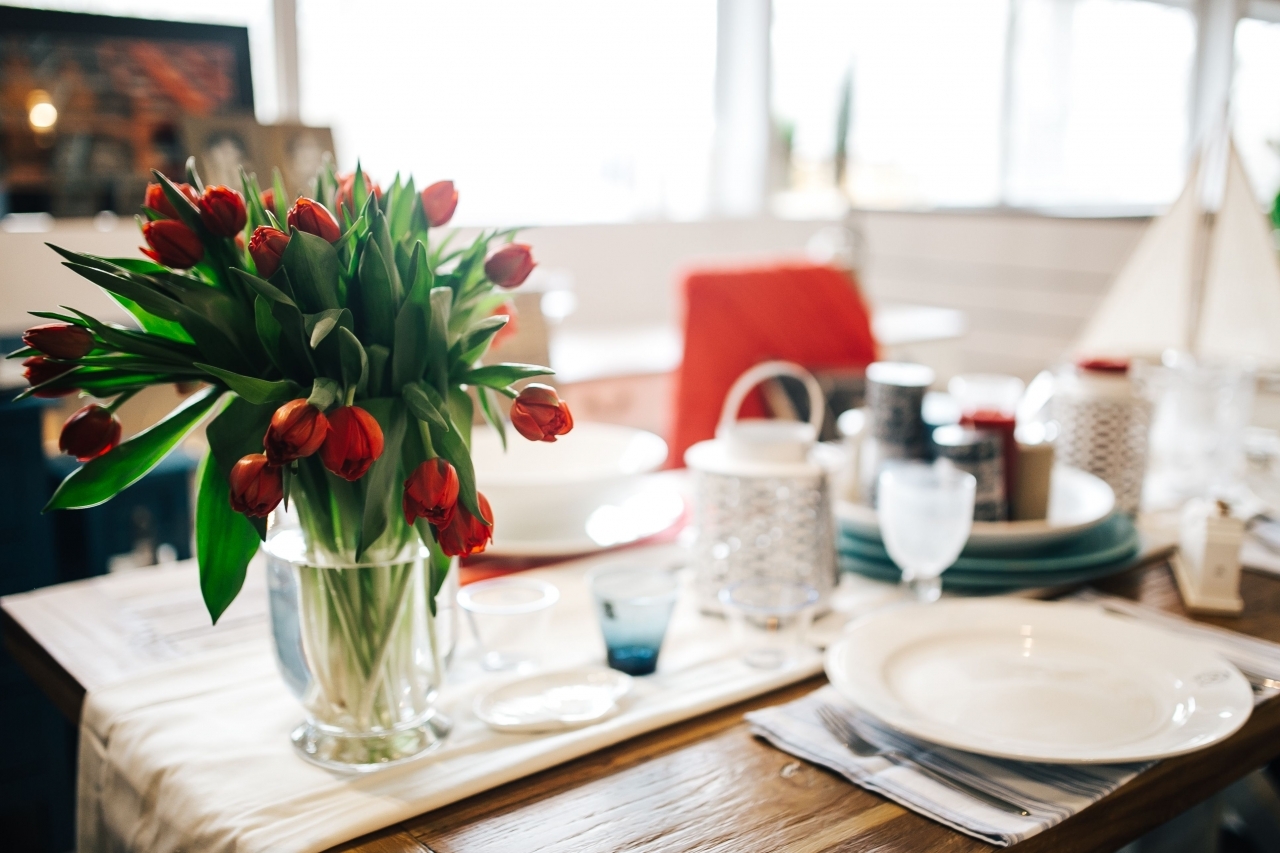 On table there is flower. Цветы на столе в ресторане. Цветы на столике в кафе. Букет цветов в ресторане на столе. Столик в кафе.