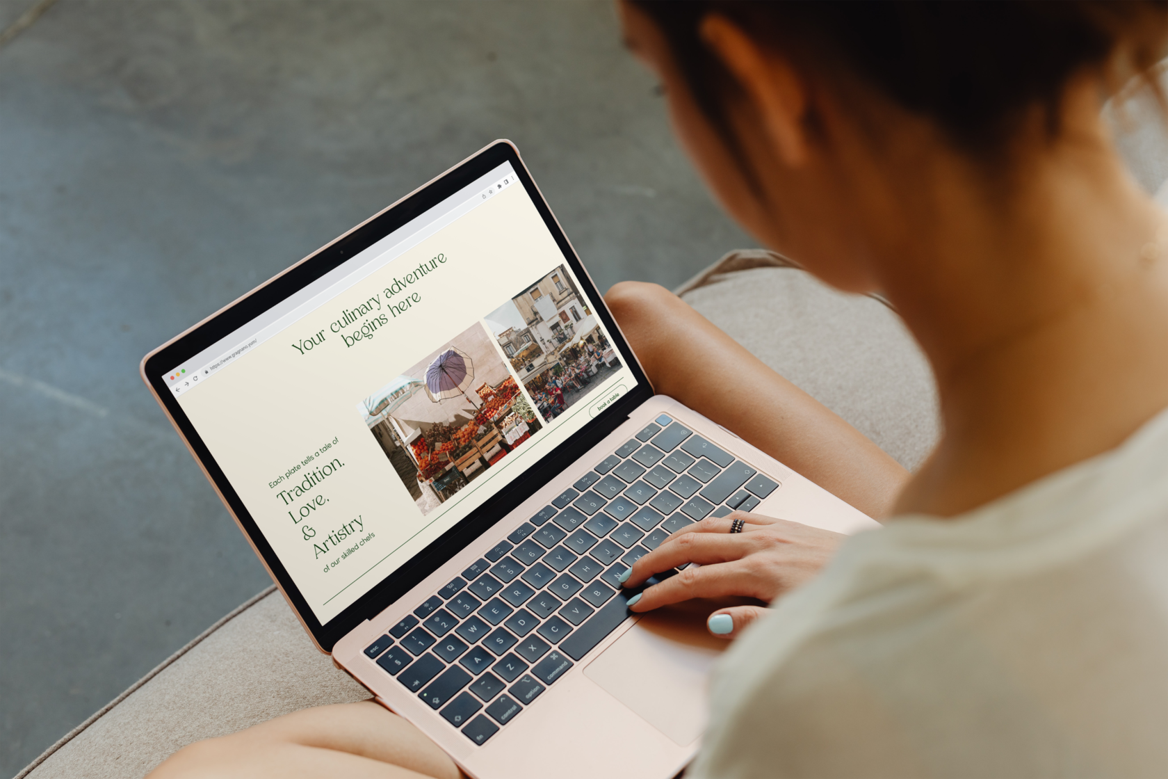 A mock up of a person holding a laptop, showing the website design for a restaurant