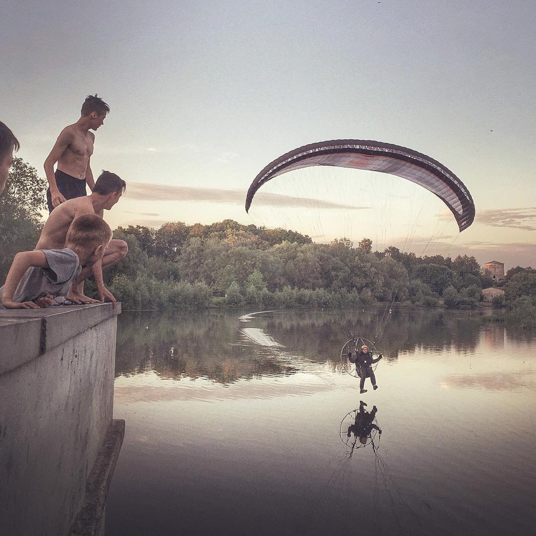 фотография Маркова: ребята смотрят на параплан над водой